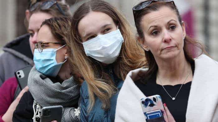 People wearing masks whilst waiting in cues