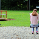 Girl sitting on swing alone