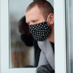 Man standing at window on coronavirus lockdown