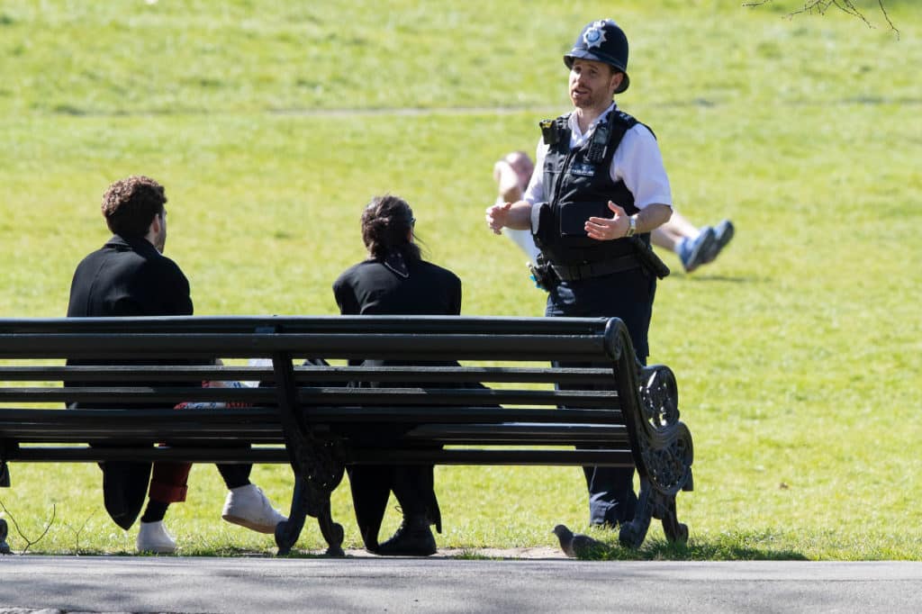 Policeman approaching someone in park