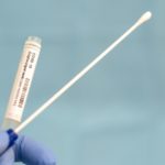 Cotton swab and test tube for Coronavirus test (COVID-19)), macro image of medical equipment in hands of healthcare professional
